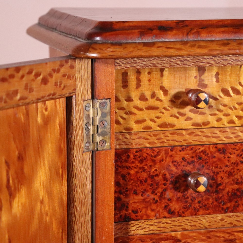 A 19th-century wooden table cabinet with two doors featuring inlaid star motifs set within pointed arches, resting on turned bun feet. View VII