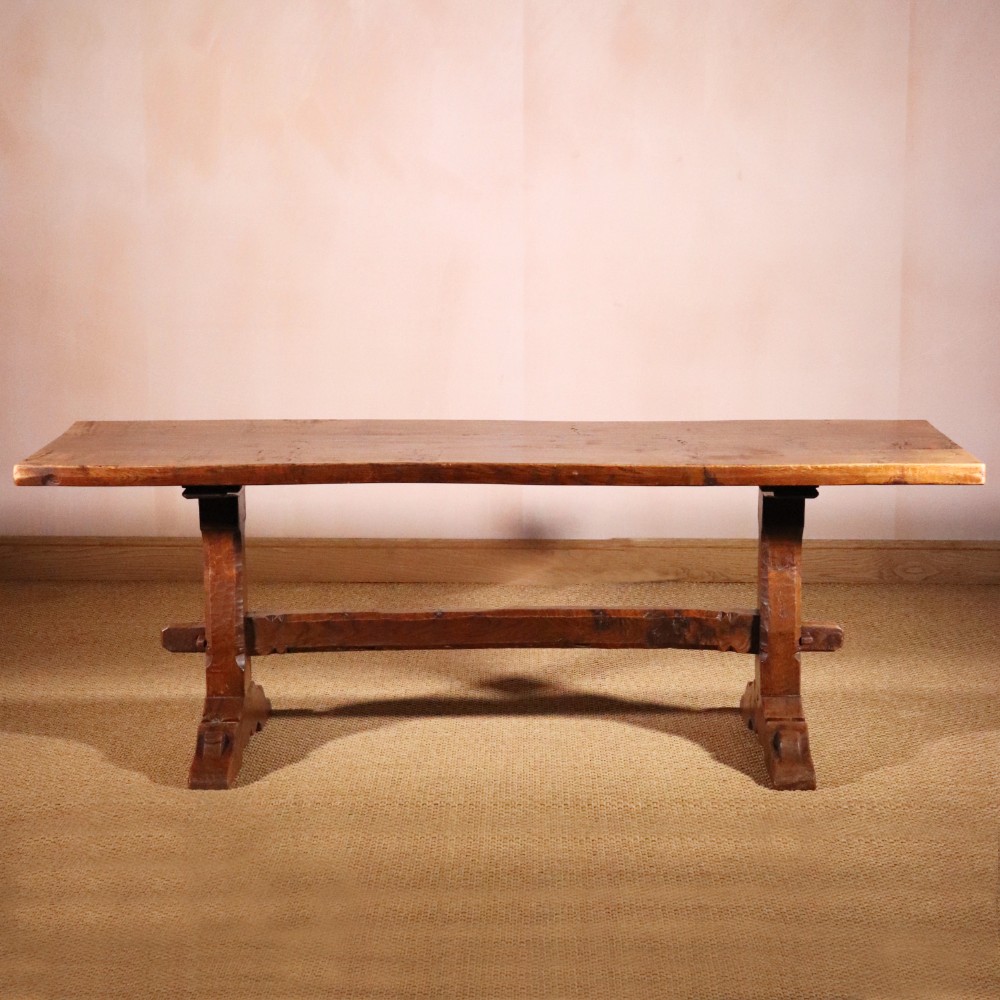 A handcrafted oak trestle dining table featuring an adzed tabletop, keyed stretcher joint, and two matching solid oak benches. View II