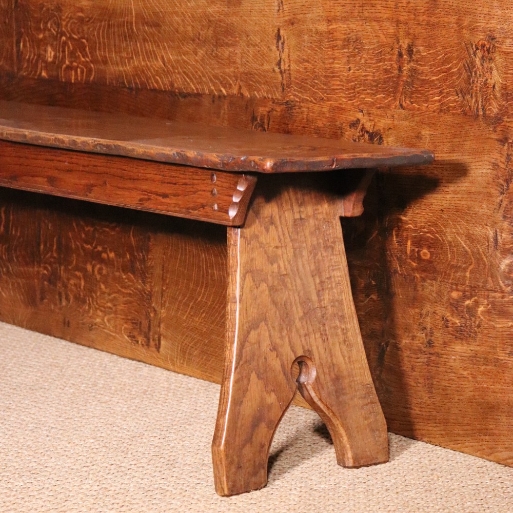 A handcrafted oak trestle dining table featuring an adzed tabletop, keyed stretcher joint, and two matching solid oak benches. View IX