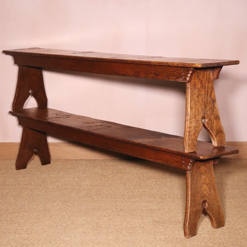A handcrafted oak trestle dining table featuring an adzed tabletop, keyed stretcher joint, and two matching solid oak benches. View XIII