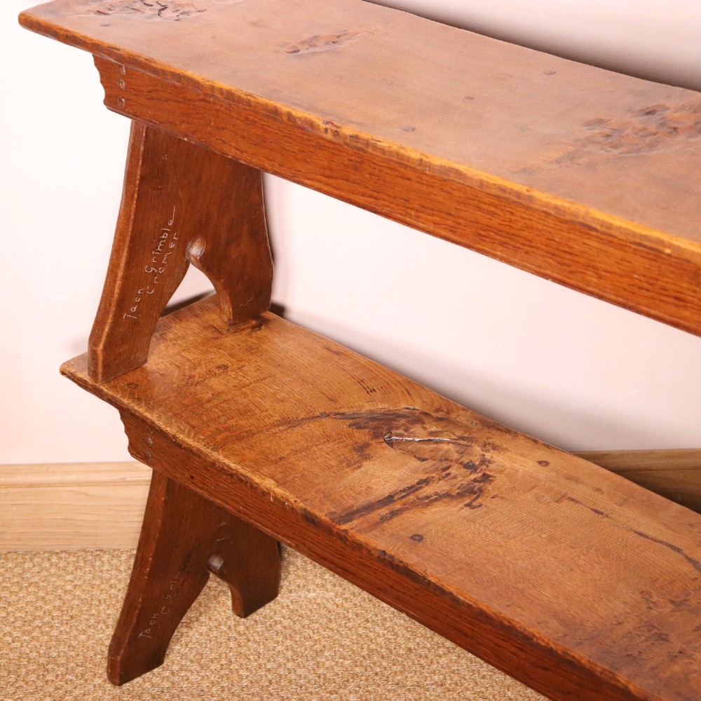 A handcrafted oak trestle dining table featuring an adzed tabletop, keyed stretcher joint, and two matching solid oak benches. View XIV