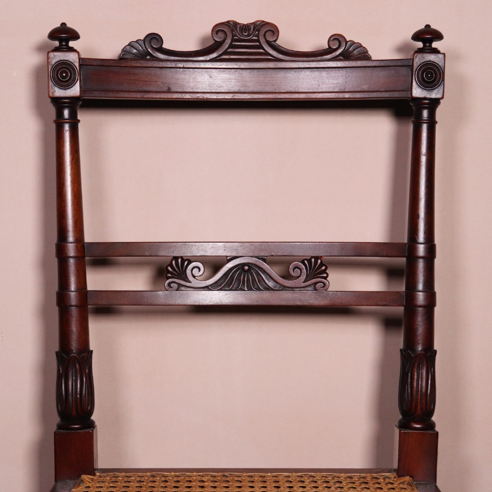 A set of six Regency period side chairs crafted from dark Goncalo Alves timber featuring carved crest rails, detailed backsplats, turned front legs, and hand-woven cane seats. View III