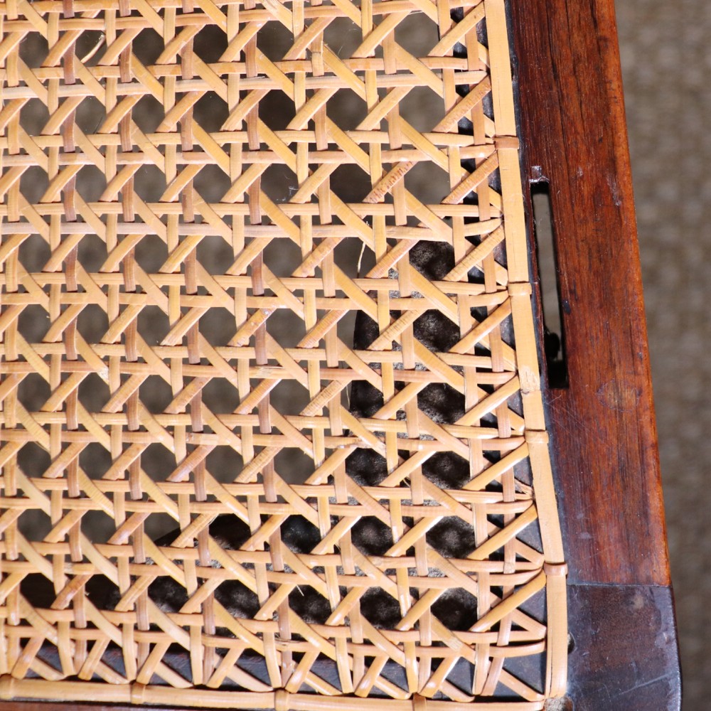 A set of six Regency period side chairs crafted from dark Goncalo Alves timber featuring carved crest rails, detailed backsplats, turned front legs, and hand-woven cane seats. View VIII