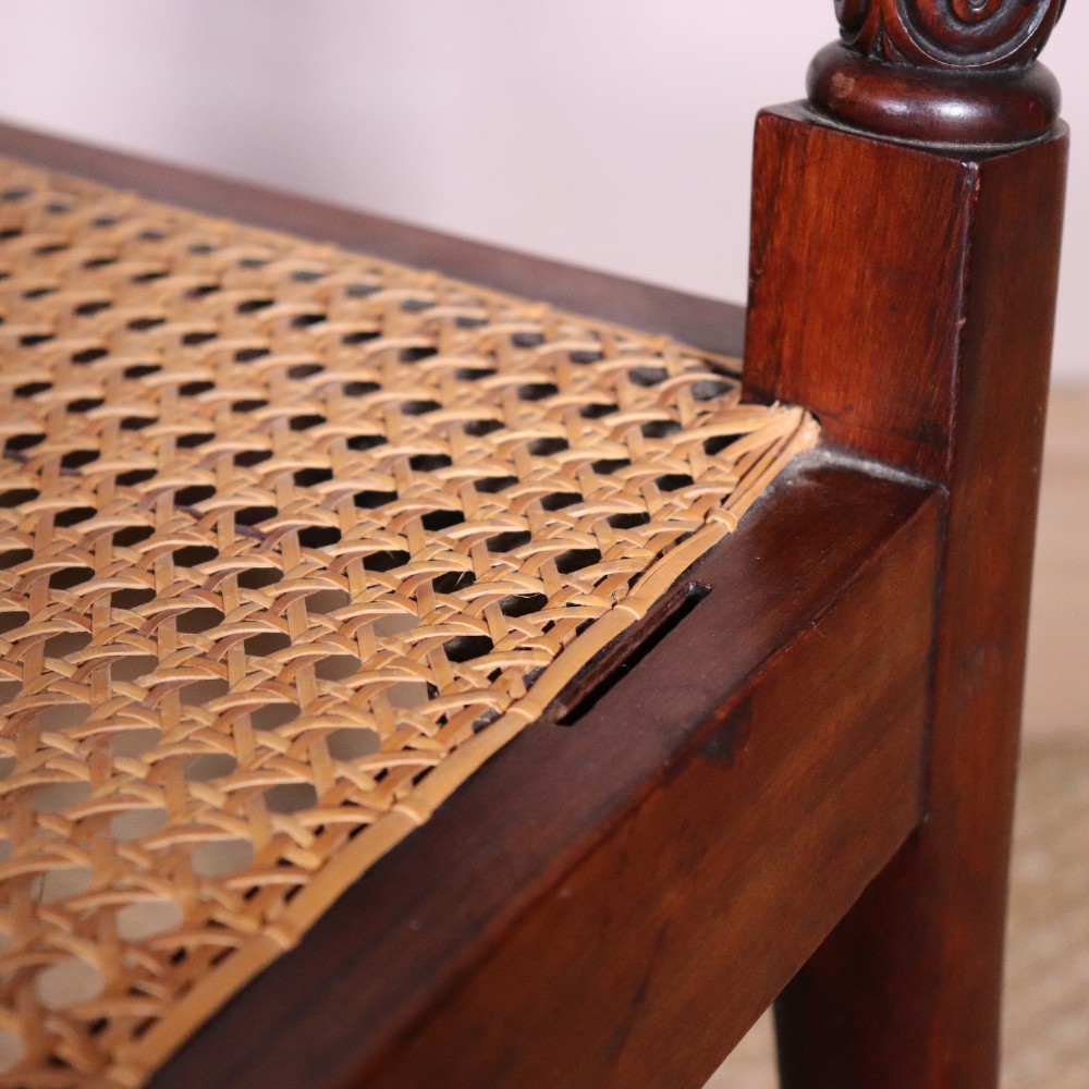 A set of six Regency period side chairs crafted from dark Goncalo Alves timber featuring carved crest rails, detailed backsplats, turned front legs, and hand-woven cane seats. View X