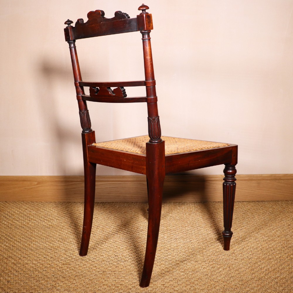 A set of six Regency period side chairs crafted from dark Goncalo Alves timber featuring carved crest rails, detailed backsplats, turned front legs, and hand-woven cane seats. View XIII