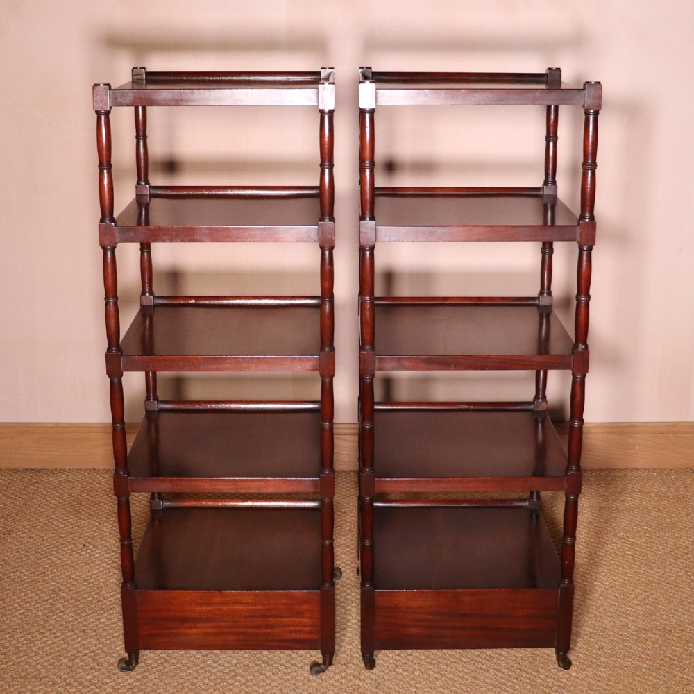 A matching pair of George IV mahogany whatnots featuring five open tiered shelves with turned supports, a single base drawer, and brass castors. View IV