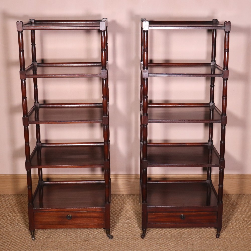 A matching pair of George IV mahogany whatnots featuring five open tiered shelves with turned supports, a single base drawer, and brass castors. View XII