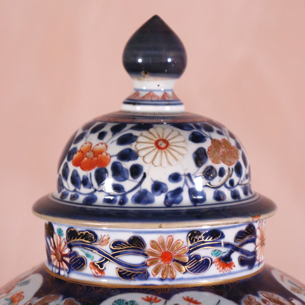 A pair of early eighteenth-century Japanese Arita porcelain lidded jars decorated with cobalt blue, red, and gold floral patterns. View II