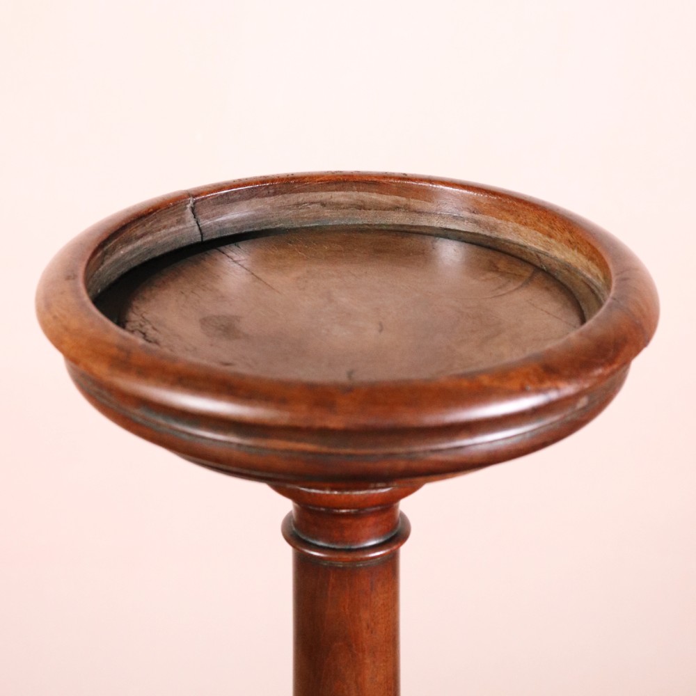 A George II dark mahogany torchere featuring a dished top, turned baluster column, and a tripod base with pad feet. View III