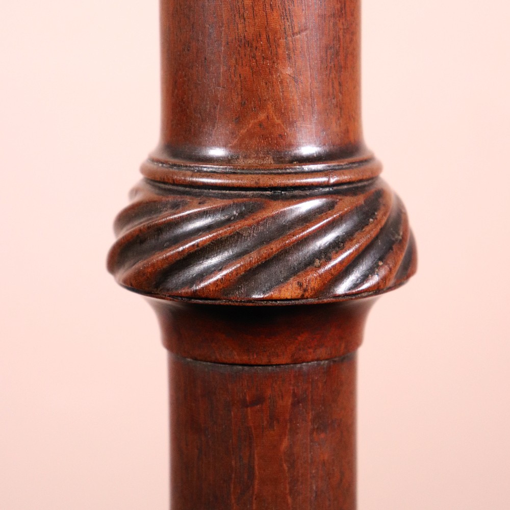 A George II dark mahogany torchere featuring a dished top, turned baluster column, and a tripod base with pad feet. View IV