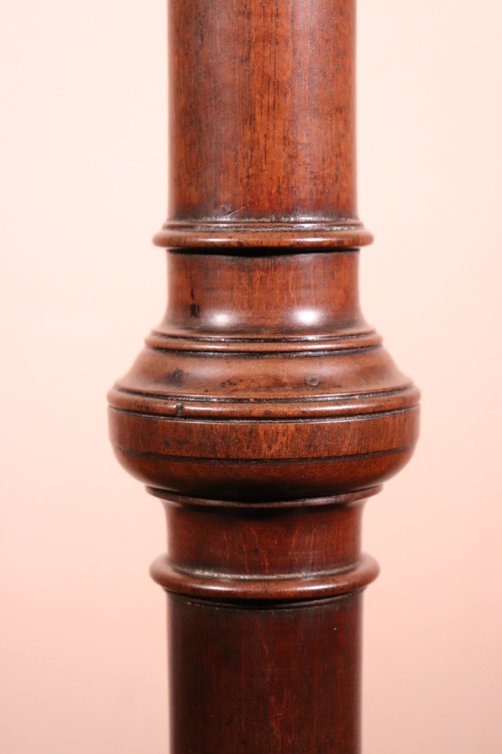 A George II dark mahogany torchere featuring a dished top, turned baluster column, and a tripod base with pad feet. View V