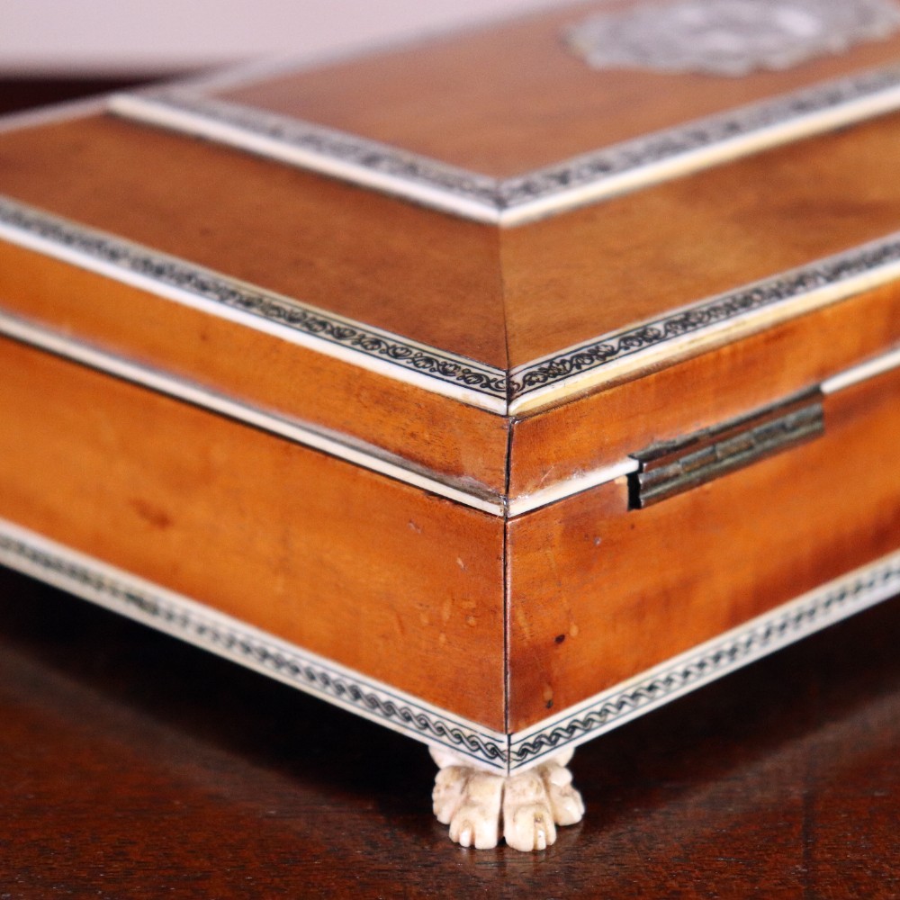 A rectangular sandalwood card box with penwork-engraved ivory borders, carved lion-paw feet, and a central medallion motif. View V
