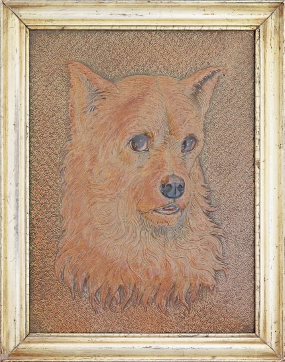 A framed embossed leather panel depicting the three-dimensional head of a terrier dog within a textured background and a pale gilt wooden frame.