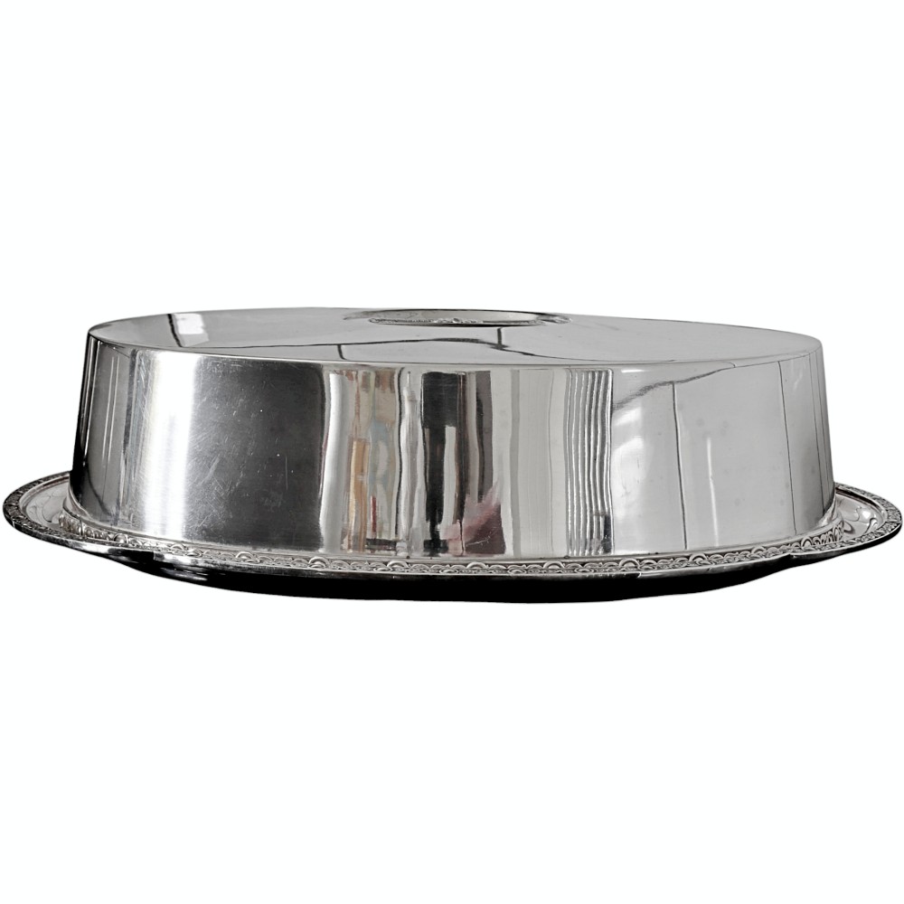 An oval silver-plated entree dish featuring a flat-topped raised cover set upon a polished tray with a decorative beaded rim.