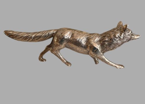 fig 1. A cast sterling silver figure of a fox depicted in a prowling posture with detailed chased fur texturing.