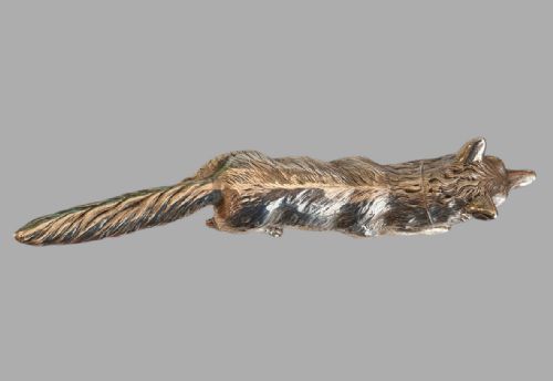 fig 2. A cast sterling silver figure of a fox depicted in a prowling posture with detailed chased fur texturing.