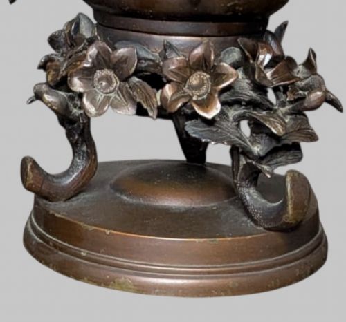 fig 5. An antique cast bronze Japanese incense burner featuring a goat finial, foliage handles, bird relief panels, and a stepped circular base.