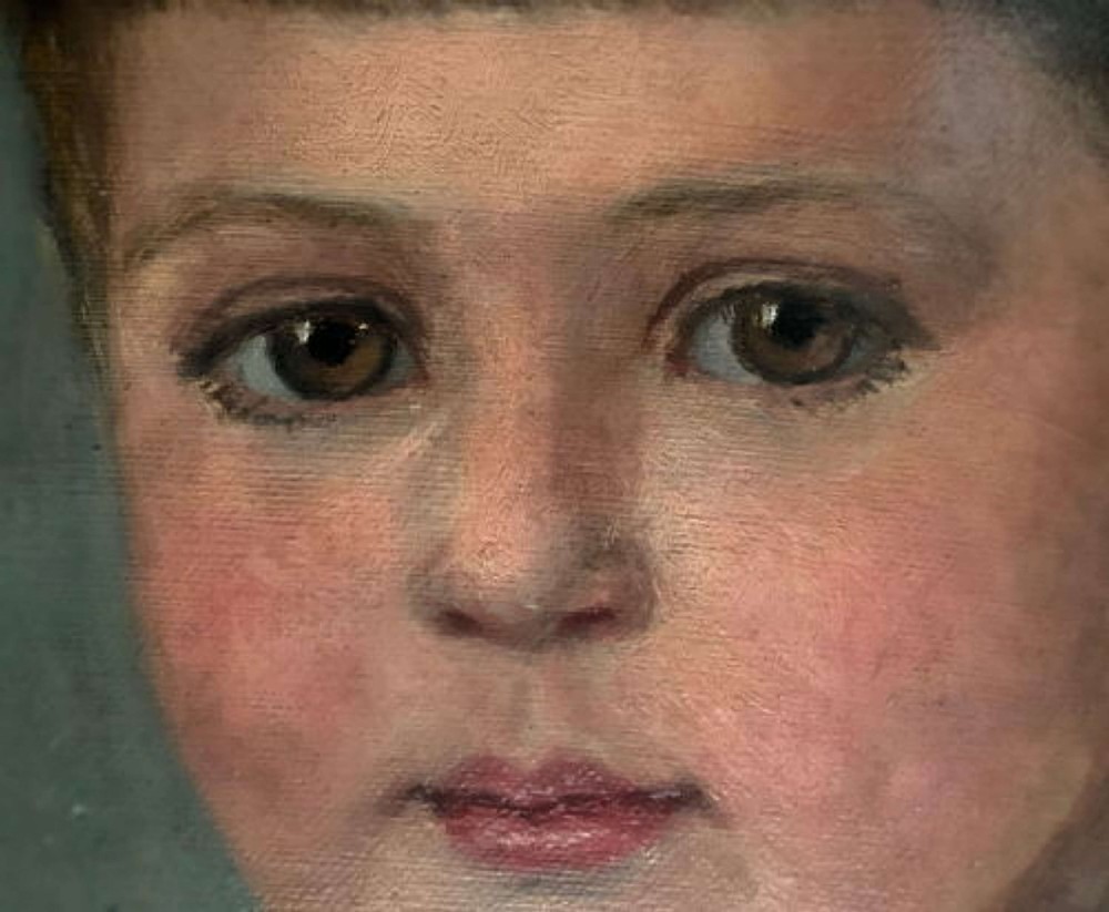 An antique oil painting on canvas depicting a child in a top hat and blue riding coat within a wooden frame featuring a gilt inner slip. View V