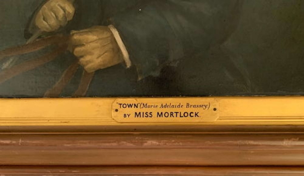 An antique oil painting on canvas depicting a child in a top hat and blue riding coat within a wooden frame featuring a gilt inner slip. View VI