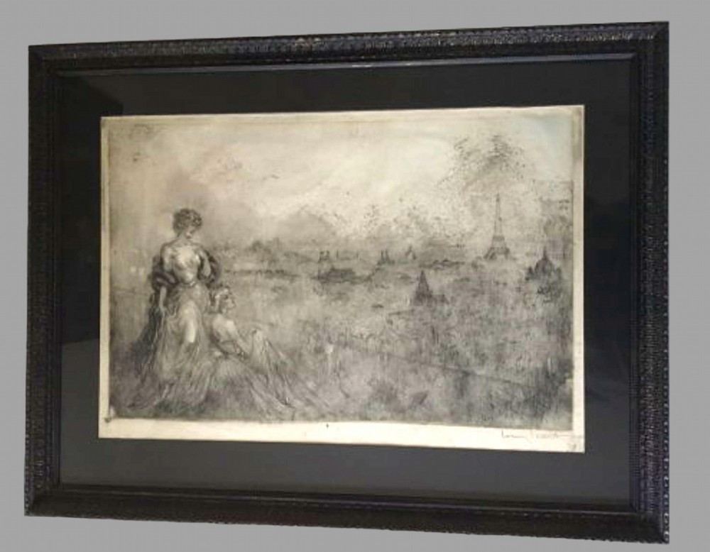 A framed monochrome Art Deco etching depicting two figures in period dress overlooking the skyline of Paris with the Eiffel Tower.
