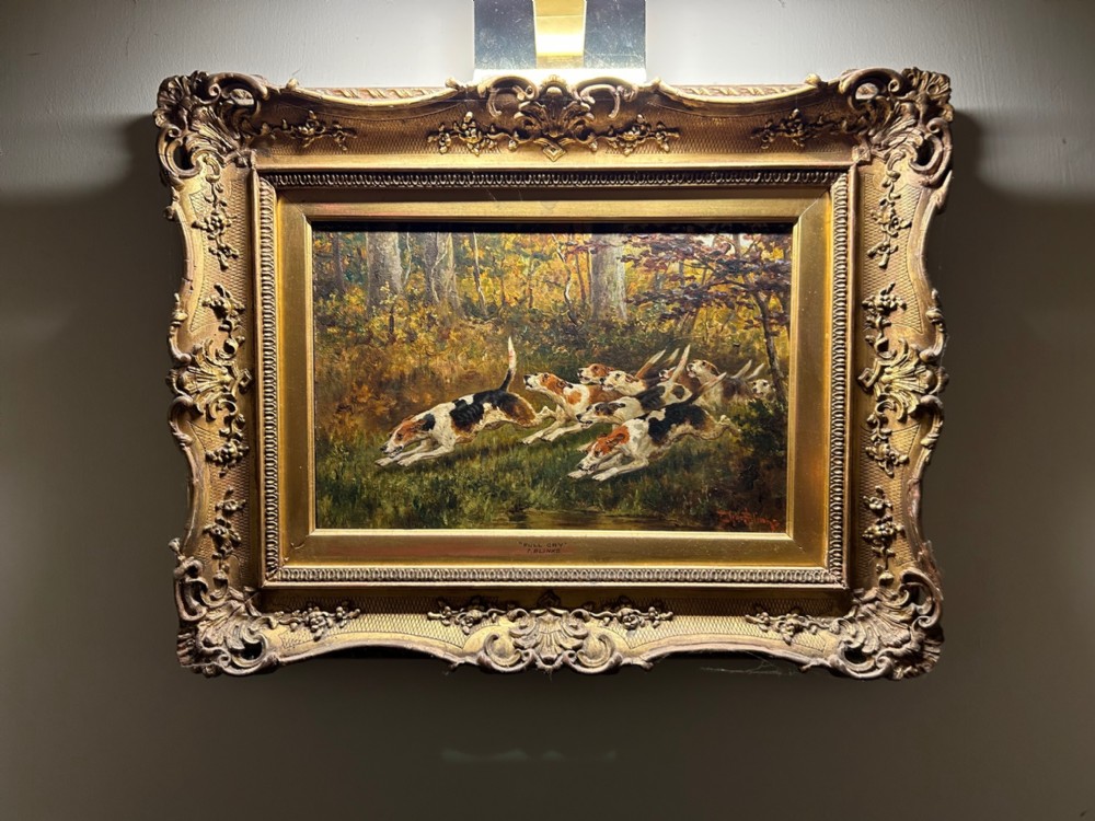 A Victorian oil painting on board by Thomas Blinks depicting foxhounds running through a woodland landscape, set in a carved gilt frame.