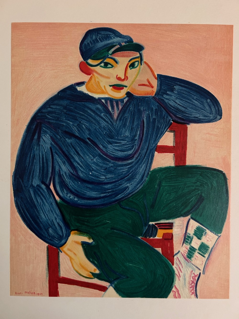 A colourful Fauvist art print depicting a seated young man wearing a blue sweater and green trousers against a pink background.