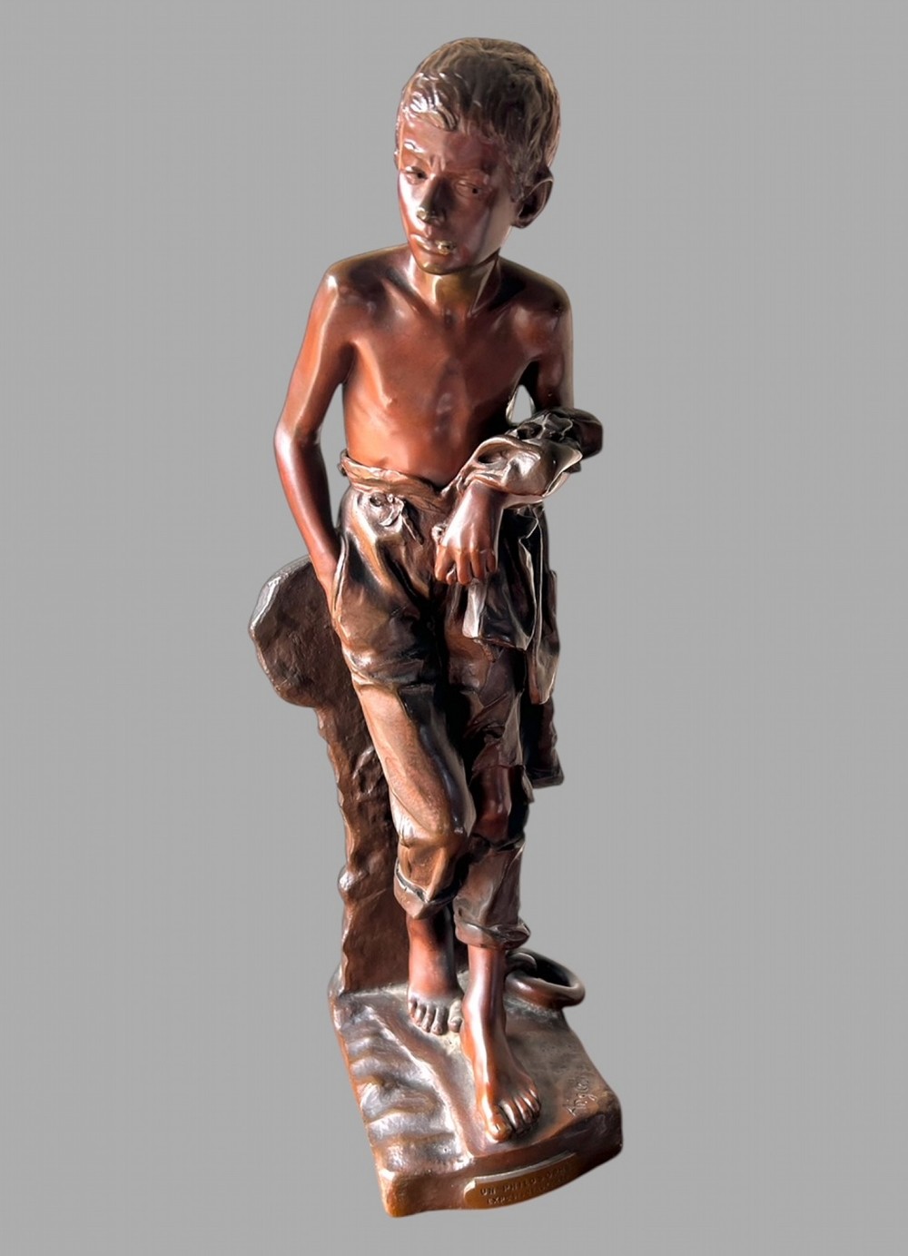 A 19th-century patinated bronze sculpture depicting a young barefoot boy leaning against a post, titled Un Philosophe by Joaquim Angles.