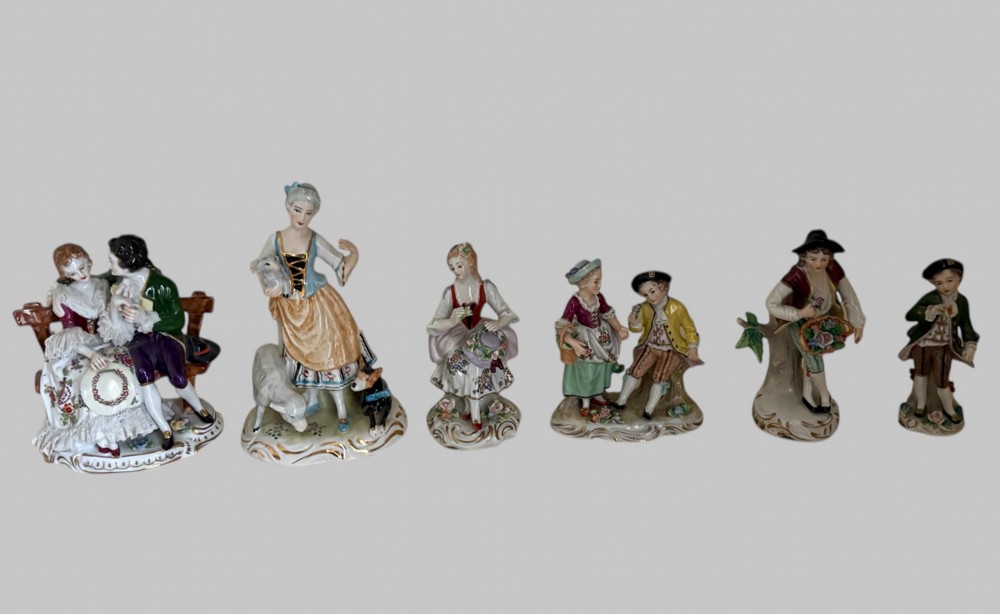 A collection of six hand-painted German porcelain figurines depicting 18th-century courtly and pastoral figures in colourful period attire.