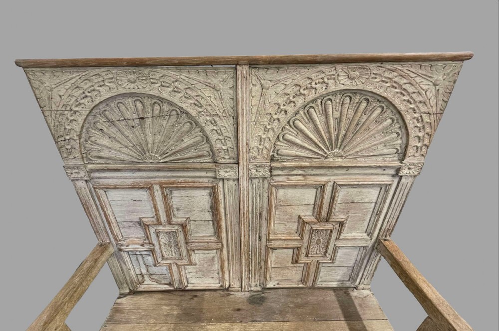 A high-backed wooden settle featuring a limed grey finish, carved lunette arches, geometric panels, and flat armrests. View IV