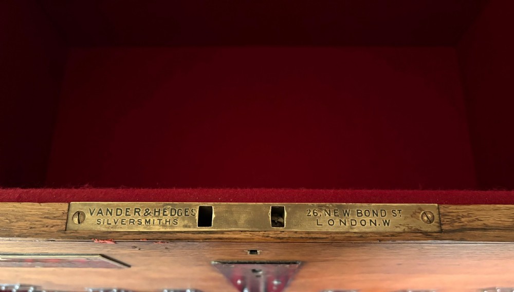 A Victorian oak travelling trunk fitted with heavy iron corner mounts, central iron lock strap, and an engraved brass nameplate. View VIII