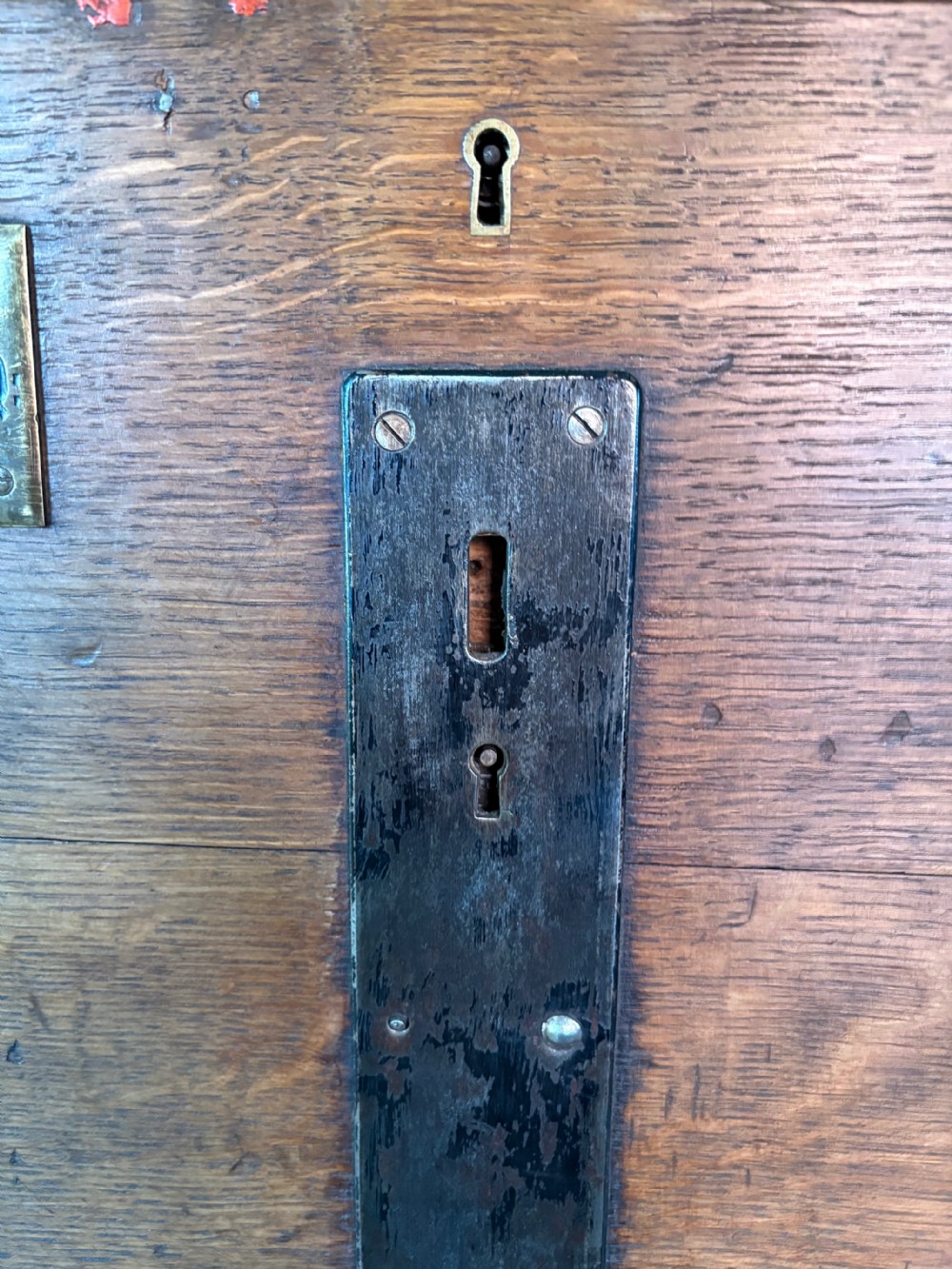 A Victorian oak travelling trunk fitted with heavy iron corner mounts, central iron lock strap, and an engraved brass nameplate. View X