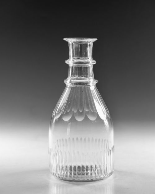 fig 1. A clear Georgian cut-glass carafe featuring applied neck rings, petal cuts around the shoulder, and vertical fluting on the base.