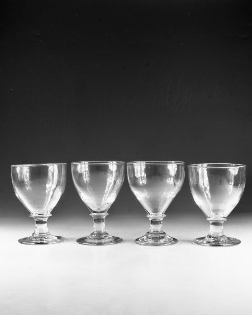 fig 1. A set of four clear hand-blown Georgian glass rummers with wide funnel bowls, short collar stems, and circular flat bases.