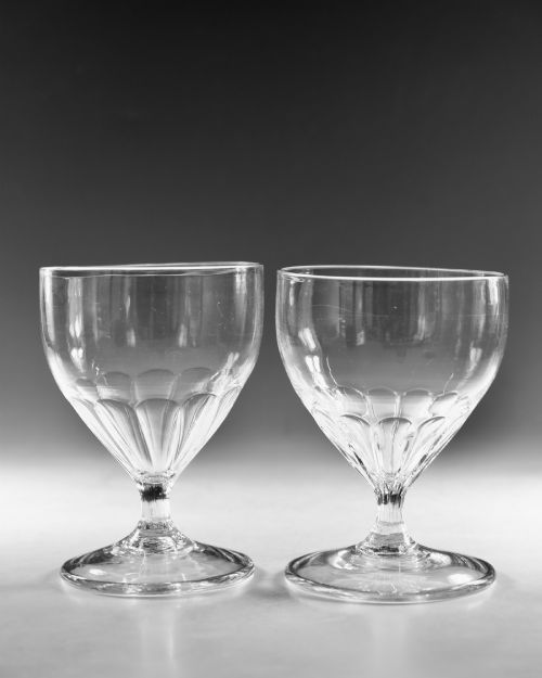 fig 1. A pair of antique Georgian clear glass rummers featuring wide cylindrical bowls with fluted lower panels on short stems and circular bases.