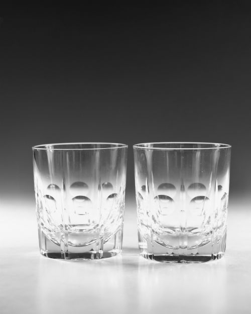 fig 1. A pair of early twentieth-century clear cut glass tumblers featuring circular lens cuts and vertical fluting.