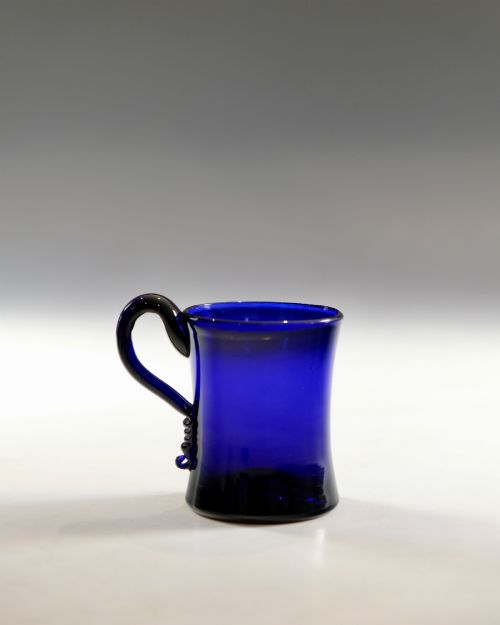 fig 1. A small Georgian cobalt blue glass tankard with a curved applied handle and a flared base.