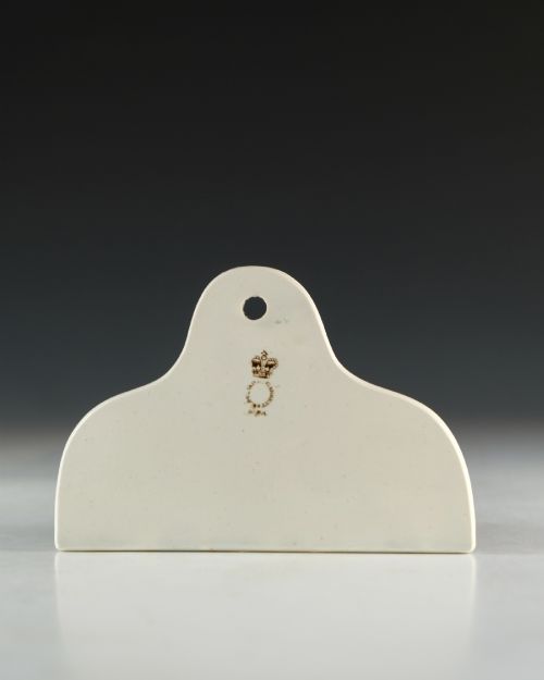 fig 2. A cream glazed ceramic wine bin label with an arched top, single hanging hole, and black printed serif text reading HOCK.