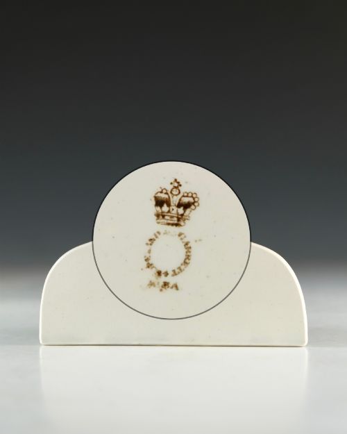 fig 3. A cream glazed ceramic wine bin label with an arched top, single hanging hole, and black printed serif text reading HOCK.