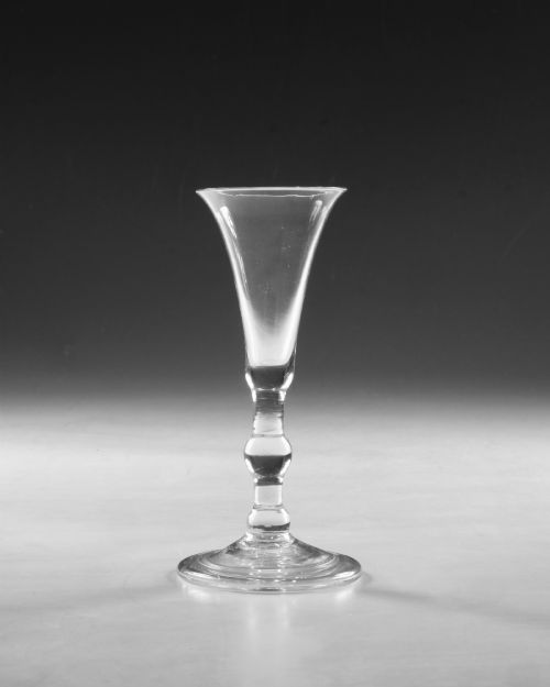 fig 1. A clear Georgian lead glass vessel featuring a flared trumpet bowl, a central knapped stem, and a circular conical foot.