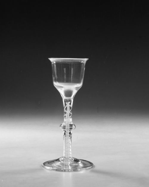 fig 1. A Georgian clear lead glass wine glass featuring a bell-shaped bowl and a knopped stem with an internal white opaque twist pattern on a conical foot.