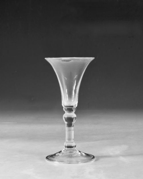 fig 1. A mid-18th century clear Georgian glass featuring a flared trumpet bowl, a knopped stem, and a broad circular foot.