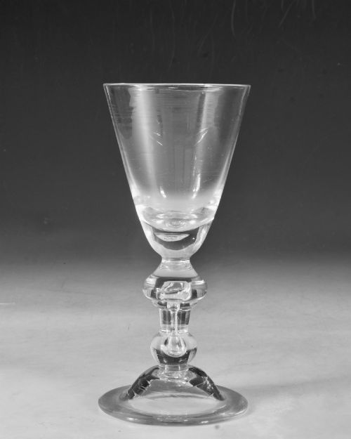 fig 1. A hand-blown clear lead glass baluster wine goblet featuring a bell bowl, knopped stem with an air tear inclusion, and a folded conical foot.