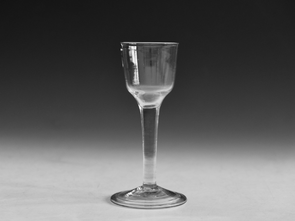 An eighteenth century plain stem wine glass made from clear lead glass featuring a bucket bowl and a folded foot. View III