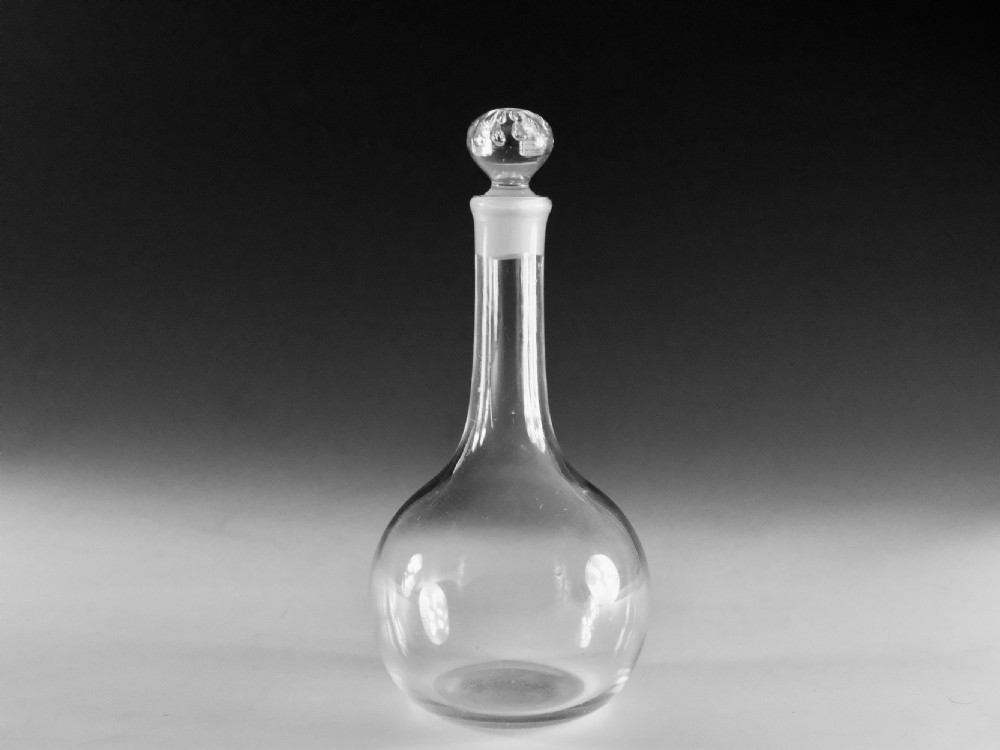 A clear glass Georgian shaft and globe decanter featuring a spherical body, long neck, and fitted round glass stopper.