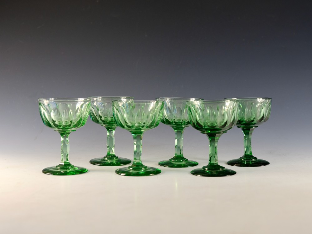 A set of six light green antique champagne glasses featuring faceted stems and scalloped bowls. View II