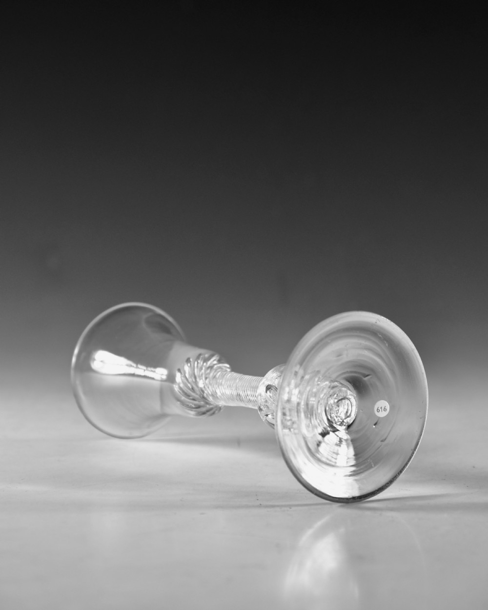 An 18th-century clear glass wine goblet featuring a flared bell bowl resting on a composite stem with internal twist decoration and a conical flat foot. View III