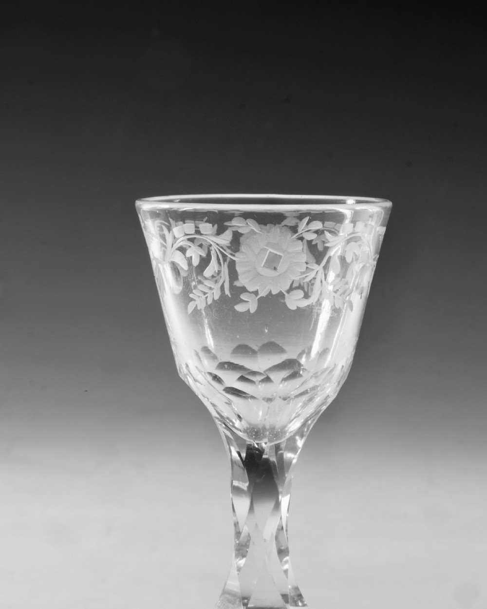 An 18th-century clear glass wine goblet featuring a wheel-engraved bird motif on the rounded bowl and a diamond-facet cut stem resting on a flat circular base. View IV