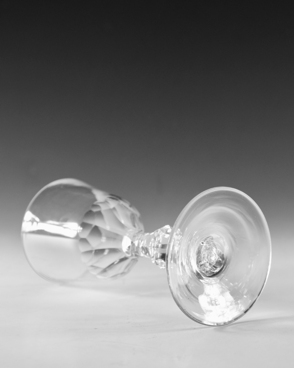 An 18th-century clear lead glass goblet featuring a faceted diamond-cut stem and a round bowl resting on a flat conical foot. View III