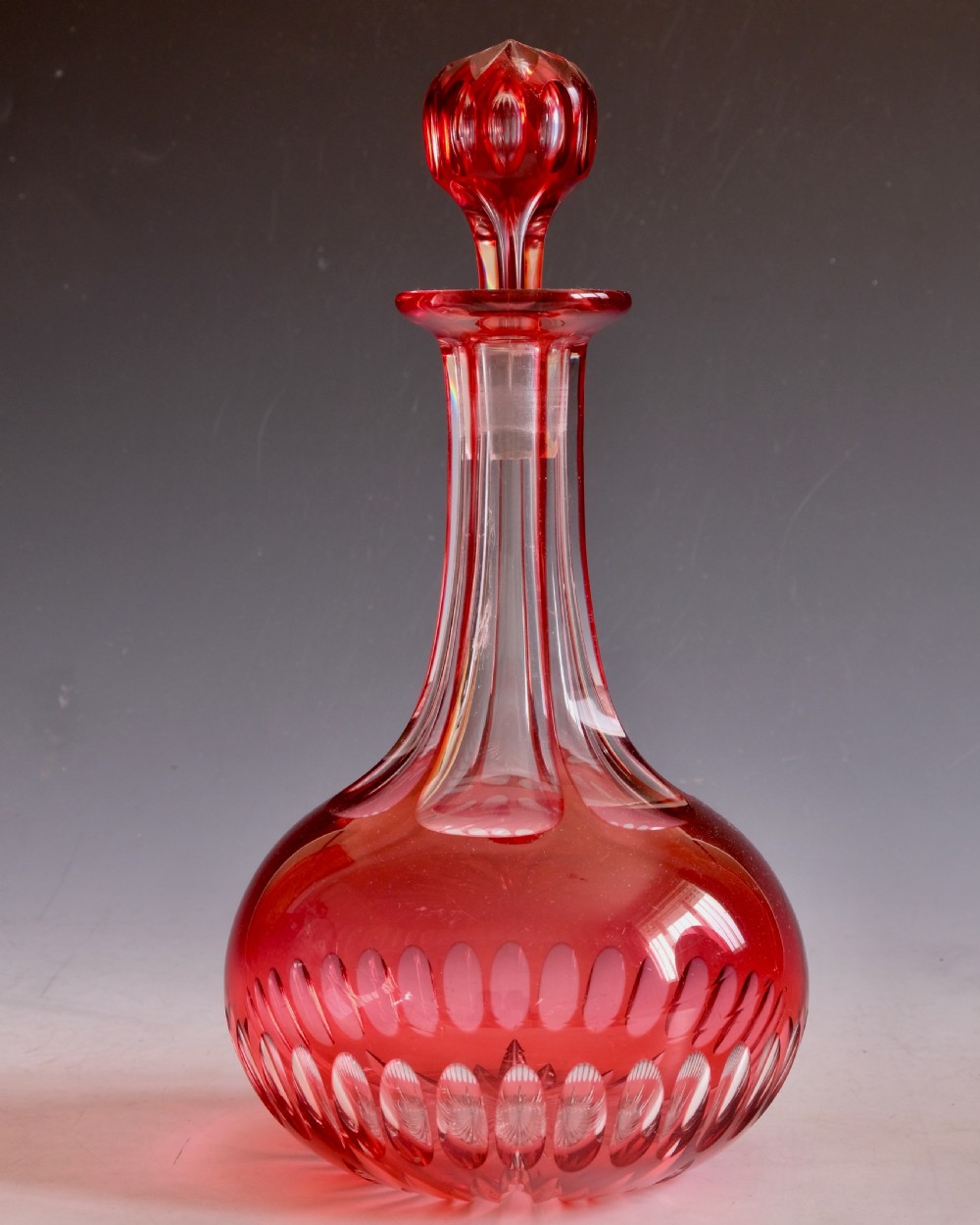 A mid-Victorian ruby overlay cut glass decanter with a matching faceted stopper and slice-cut neck. View III