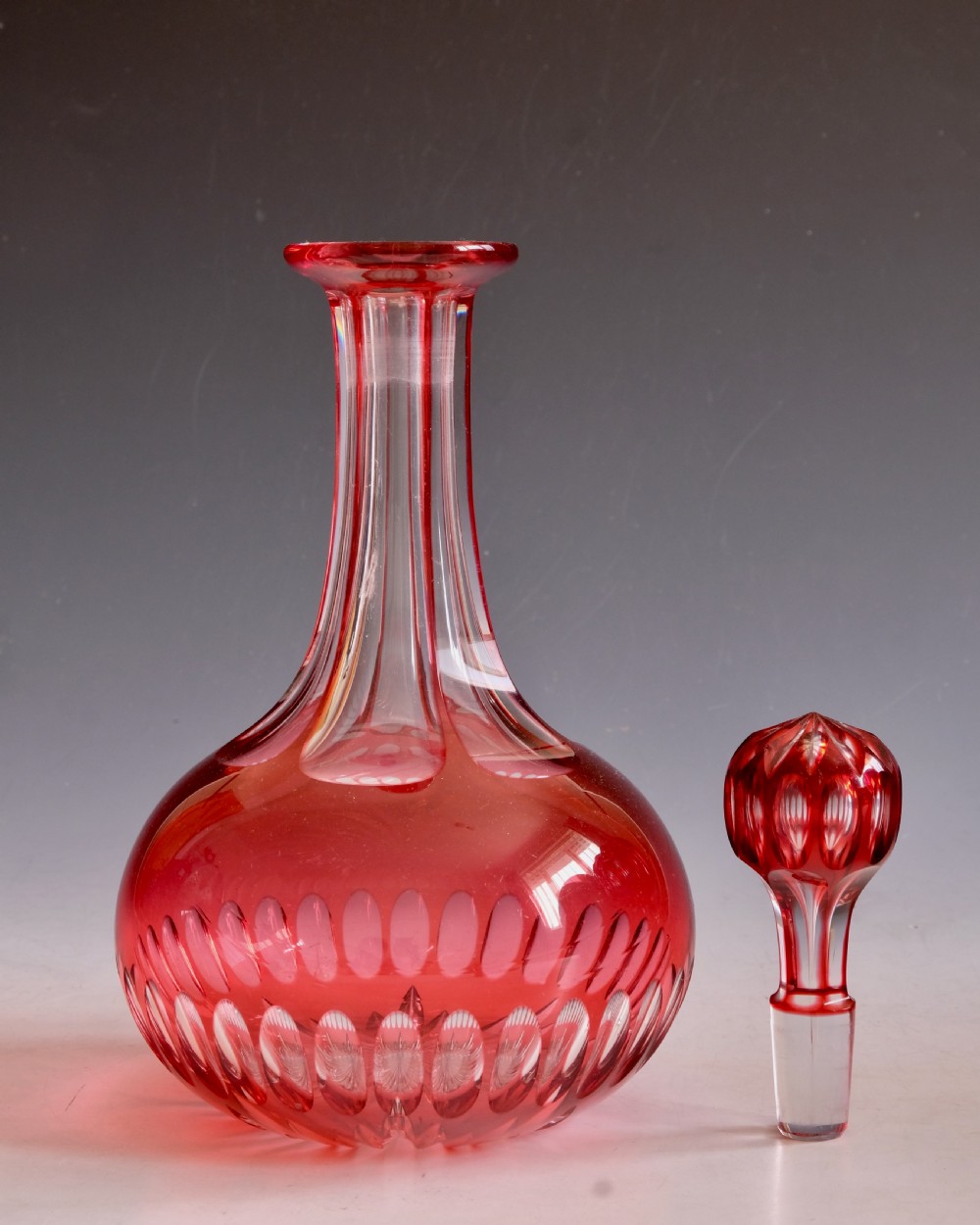 A mid-Victorian ruby overlay cut glass decanter with a matching faceted stopper and slice-cut neck. View V